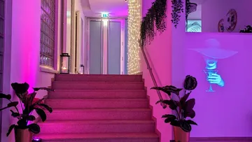 Staircase with colorful lights and projected figure.