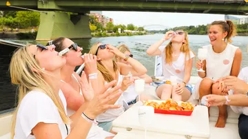 Gruppierung von Frauen trinkt und genießt Essen auf Boot.