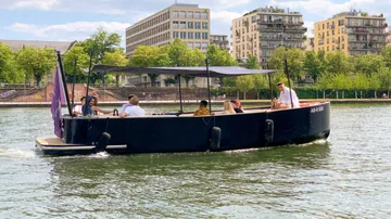 A boat sails on a body of water with passengers.