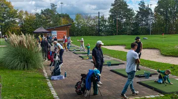 Golfspieler üben auf Übungsplätzen in einem Park.