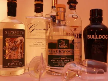 Schnapsflaschen stehen, Gläser liegen daneben. Bar-Setup.