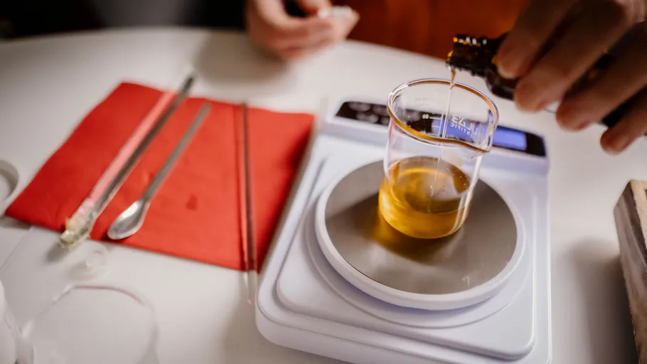 Liquid is poured into a beaker on a scale.