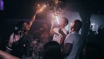 Leuchtende Wunderkerzen werden in einem Nachtclub geschwenkt.