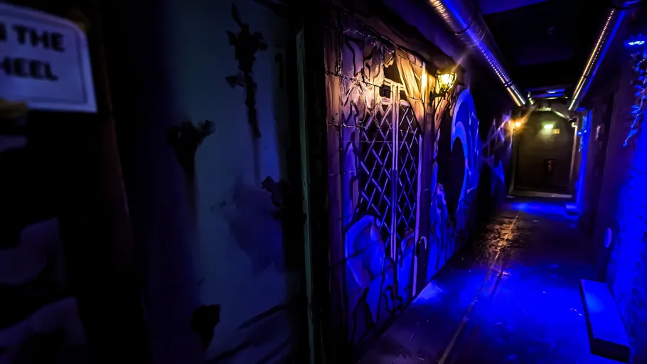 Dark hallway with graffiti and blue lighting.