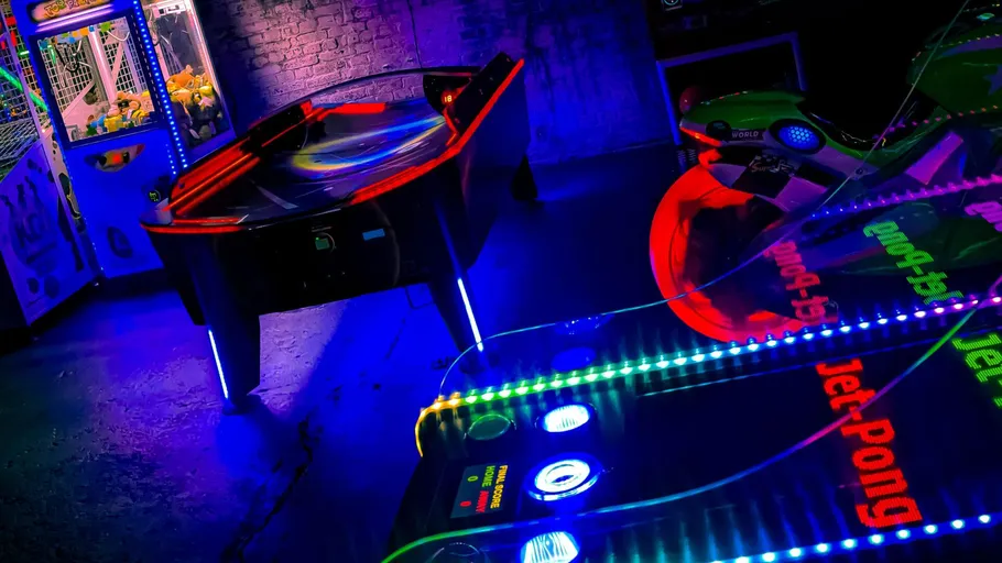 Tischspiel leuchtet flott in einem dunklen, bunten Raum.