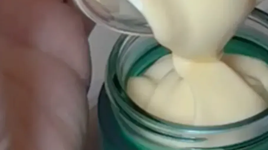 Cream being poured into a jar.