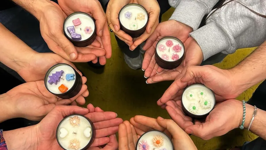 Group holds homemade candles in decorated glasses