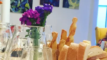 Colourful flowers decorate a set table with bread.