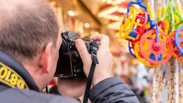 Person fotografiert bunte Spielzeuge auf einem Markt.