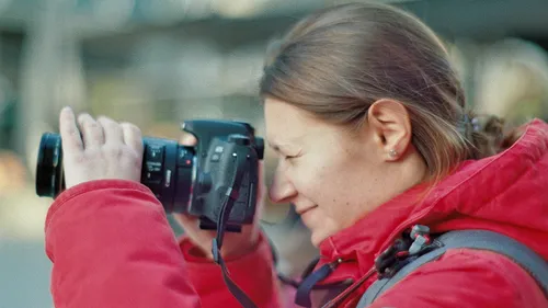 Person taking photo with camera outside.