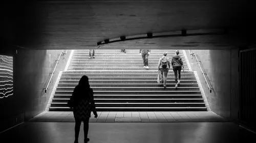 Silhouetted figures walking in underground passage