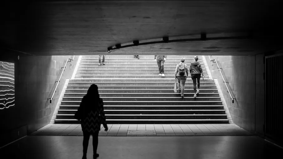 Silhouetted figures walking in underground passage