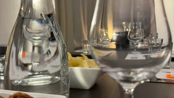 Wasserkrug und Gläser auf einem gedeckten Tisch.