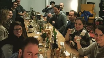 Gruppenausflug: Menschen sitzen am Tisch und stoßen an.