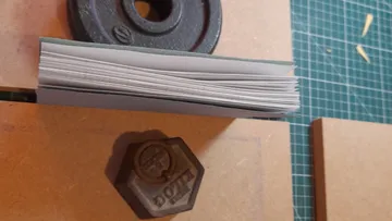 Weight plate holds a pile of paper on a table