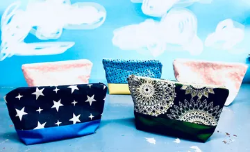 Colourful bags stand on a table against a blue background.