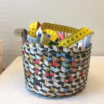 Ein geflochtener Korb hält Messbänder und Stifte.