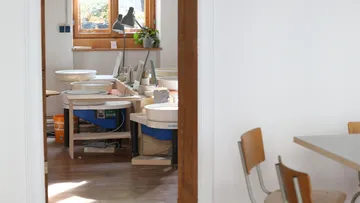 A pottery room with workplaces and window light.