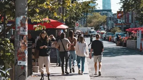 People walk along a busy street with umbrellas.