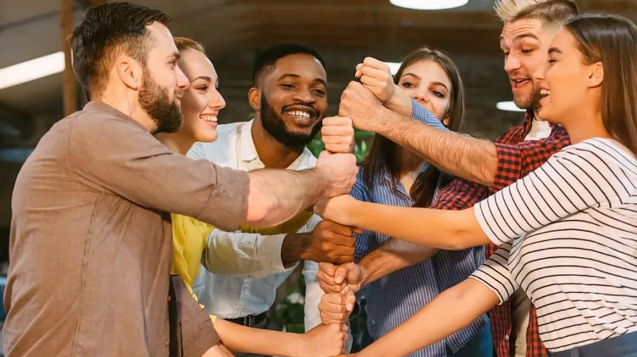 Six people shake hands in a group.