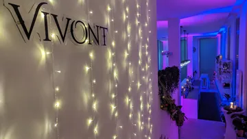 Wall with lights and the word 'VIVONT'; cozy atmosphere.