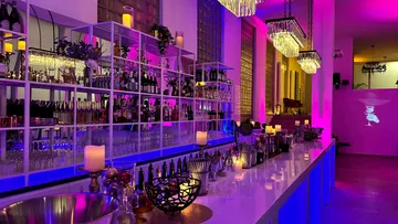 A modern bar with drinks, a cozy atmosphere and soft lighting.