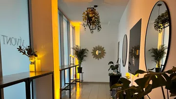 Ein Flur mit Pflanzen, Spiegeln und sanfter Beleuchtung.