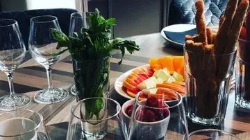Gläser, Kräuter und Obst auf einem Tisch arrangiert.