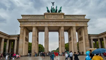 Das Brandenburger Tor steht majestätisch; Menschen bewegen sich darunter.