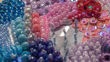 Colourful beads are arranged on a table.