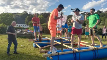 People stand on a raft and interact outdoors.