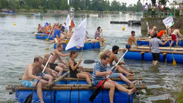 People paddle in rafts on a body of water.