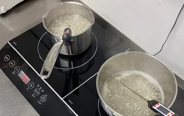 Zwei Töpfe kochen Wasser auf einem Induktionsherd.