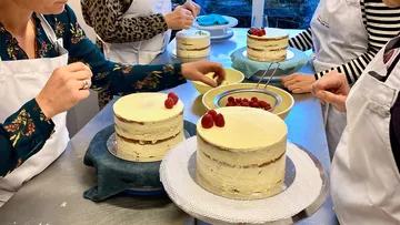 Delicious cakes are decorated while people work together.