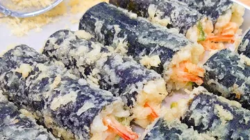 Fried sushi rolls are laid out on a plate.
