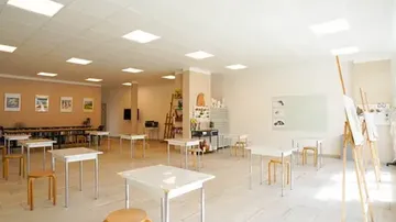 Empty tables stand in a bright, artistic space.