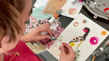 Frau gestaltet kreative Kunst mit verschiedenen Materialien und Farben.