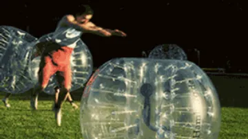 A player jumps over a large inflatable bubble.