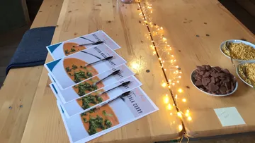 Menüs mit Curry-Gerichten liegen auf einem Tisch.