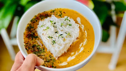 Bowl of heart-shaped rice surrounded by sauce.