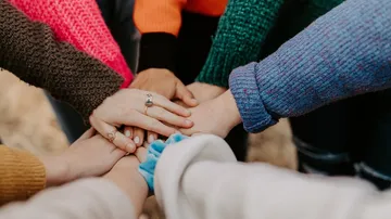 Hands touch in the middle to show community.