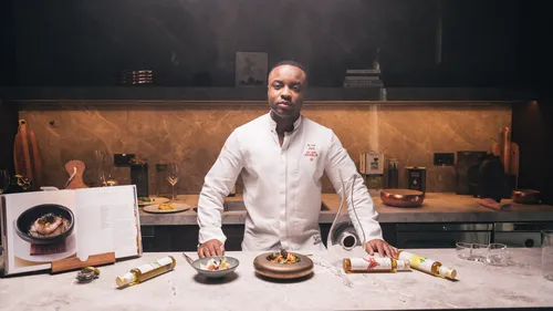 Koch prepares dishes in a modern kitchen setting.
