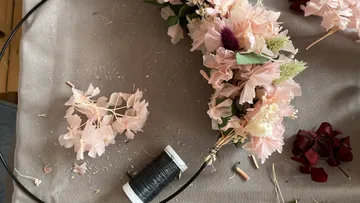 Flower arrangement is made on a table using tools.