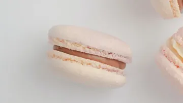 Macarons lie on a white surface, filled with colorful colors.
