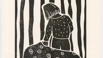 Girl caresses a big mushroom in the forest.