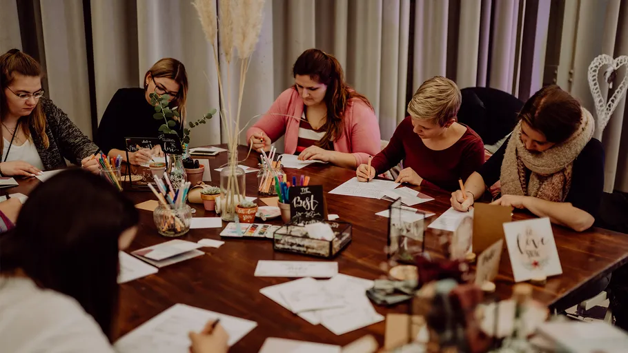 People draw and write on a set table.