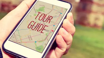 Smartphone displays a map that says “TOUR GUIDE.”