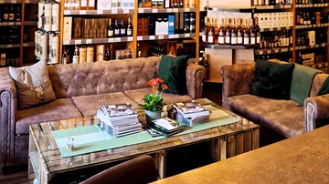 Two cozy sofas stand in front of a glass table in a shop.