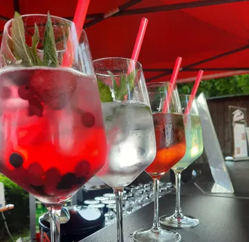 Drinks are in glasses on a table under sunshade.