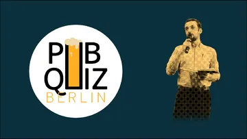 Man speaking at a pub quiz in Berlin.